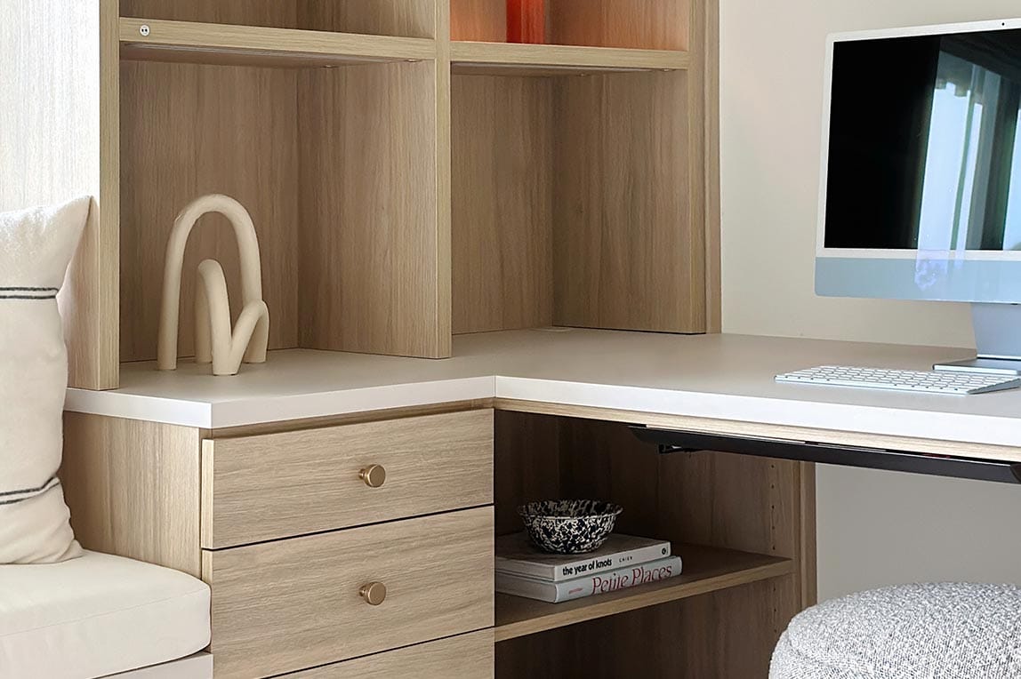 Custom vertical shelving with LED lights for home office made by California Closets