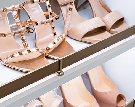 Custom walk in closet design with open shelves and shoe storage by California Closets